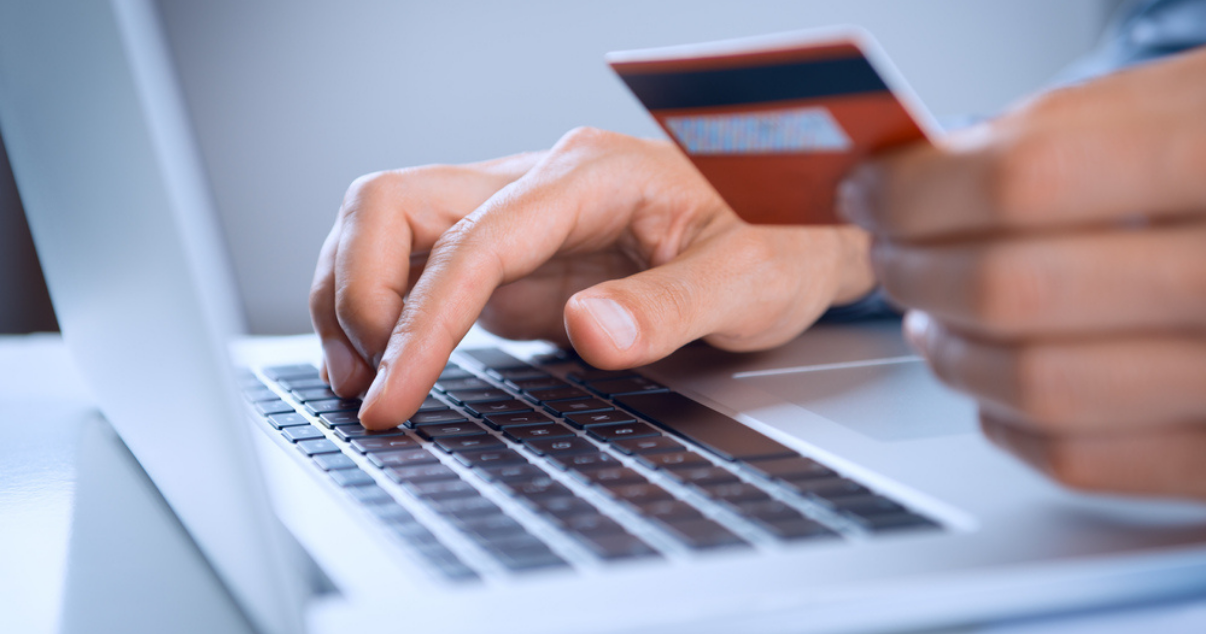 Man holding his credit card while looking for the best payment processor