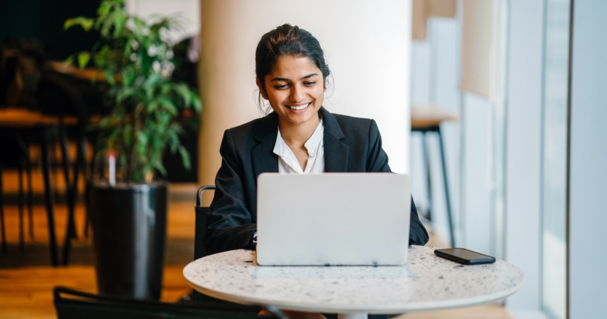 Woman using her computer working on key saas metrics