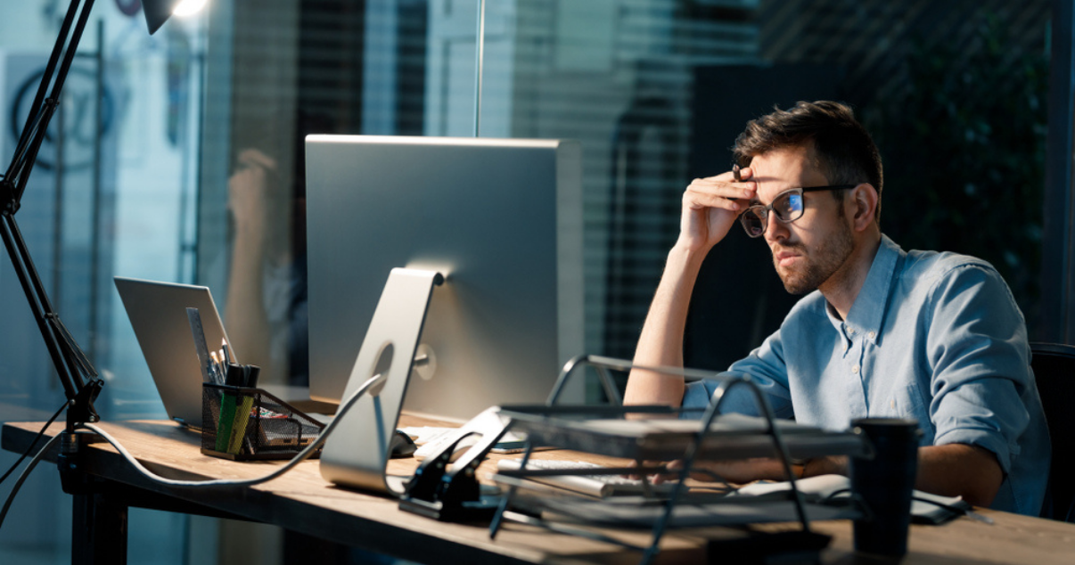 Frustrated businessman looking at his computer at the office